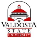 Logo of Valdosta State University featuring a red-roofed building and text in black and red.