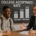 Two students sit with a man in a suit at a table in front of a chalkboard displaying college acceptance rate and diversity metrics.